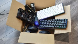 An open cardboard box containing a variety of gaming PC components and peripherals.